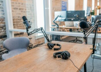 two black headphones on brown wooden table