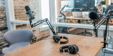 two black headphones on brown wooden table