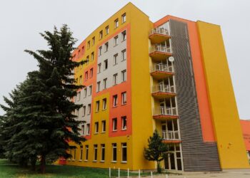 orange concrete building near green trees during daytime